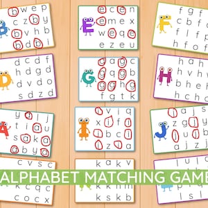 May include: A set of educational alphabet matching game cards featuring colorful cartoon characters and grids of lowercase letters. Several cards show specific letters circled in red ink, designed to help children identify and match letters.