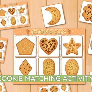 Könnte beinhalten: Ein Keks-Zuordnungsspiel mit einem großen rechteckigen Spielbrett mit der Aufschrift COOKIE BOX und sechs quadratischen Feldern, die Abbildungen von fünfeckigen, herzförmigen, sternförmigen, rautenförmigen, ovalen und länglichen Keksen zeigen.