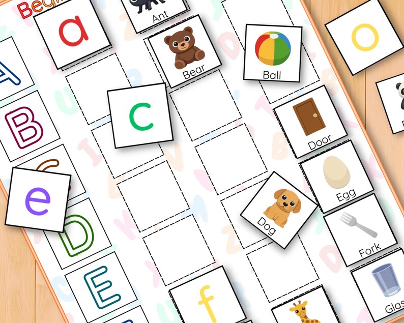 May include: Alphabet matching game with colourful illustrations. Features letter cards with images of an ant, bear, ball, door, dog, egg, and fork. Designed for early learning and educational play.
