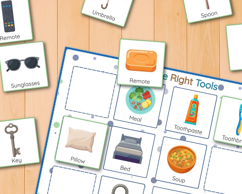 May include: A colorful educational game with illustrated cards and the text "The Right Tools." The cards feature images of everyday objects like a remote, sunglasses, key, pillow, bed, and soup. The game is set on a light wood-grain surface.