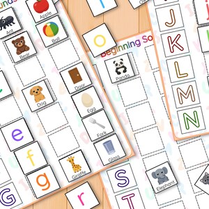 May include: Educational game with alphabet letters and picture cards. Includes images of an ant, apple, bear, ball, dog, door, egg, fork, giraffe, glass, elephant, and cat. Designed to teach beginning sounds.