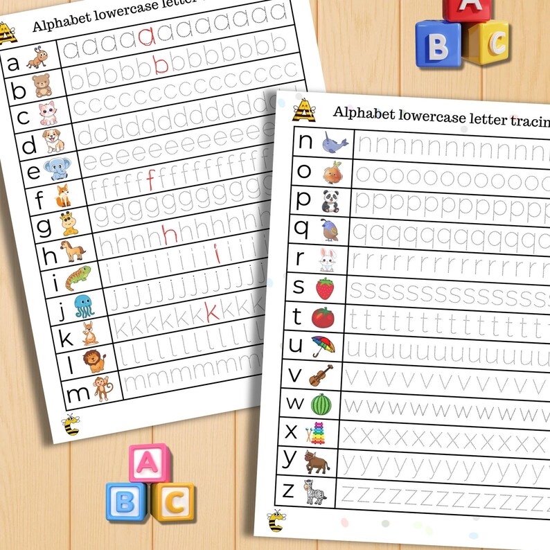 K&ouml;nnte beinhalten: Zwei wei&szlig;e Arbeitsbl&auml;tter zum Nachzeichnen des Alphabets mit Kleinbuchstaben und Illustrationen. Die Arbeitsbl&auml;tter tragen die Aufschrift "Alphabet Kleinbuchstaben-Tracing". Drei bunte ABC-Bl&ouml;cke befinden sich im Vordergrund, auf einem Holzgrund.