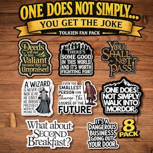 May include: A collection of eight stickers with quotes and imagery from the Lord of the Rings. The stickers feature quotes like "You Shall Not Pass!" and "What about Second Breakfast?" with related graphics. The stickers are on a wooden background.