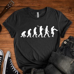 Monty Python Silly Walk T-Shirt: Evolution des Mannes Grafik-T-Shirt