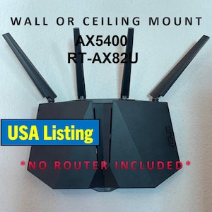 May include: Black router with four antennas, labeled "AX5400 RT-AX82U." The text "WALL OR CEILING MOUNT" is above the router. A blue banner reads "USA Listing," and the text "NO ROUTER INCLUDED" is below.