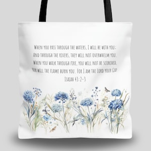 May include: White tote bag with a blue floral design and a quote from Isaiah 43:2-3: "When you pass through the waters, I will be with you: And through the rivers, they will not overwhelm you. When you walk through fire, you will not be scorched, nor will the flame burn you. For I am the Lord your God."