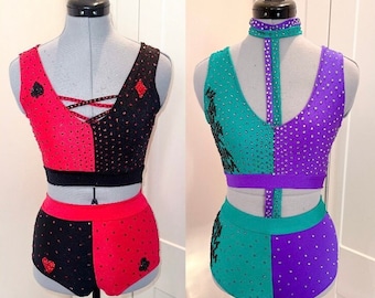 Puede incluir: Dos trajes de baile, uno rojo y negro con un diseño de diamante y pica, el otro verde y morado con un diseño negro. Ambos trajes tienen pedrería.