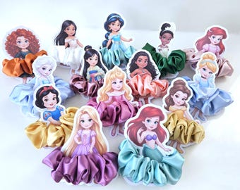 May include: A collection of colorful hair scrunchies featuring various cartoon princess characters. Each scrunchie has a satin fabric base in shades of blue, pink, yellow, and green, with a princess image attached.
