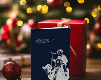 May include: A navy blue greeting card with the text "God bless us everyone!" and a black and white illustration of a man carrying a child on his shoulders. A red gift box and a red ornament are in the background.