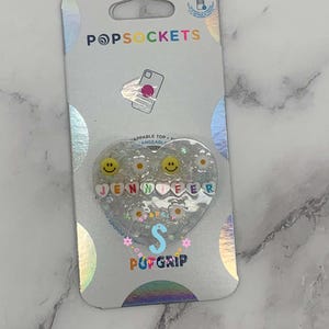 Suporte para celular Pop Grip personalizado com nome em formato de coração e resina.
