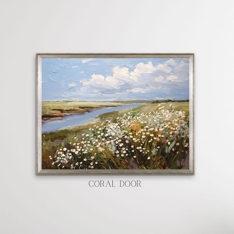 May include: Oil painting of a landscape with a river, wildflowers, and a cloudy sky. The artwork is framed in a silver-coloured frame. The text "CORAL DOOR" is printed at the bottom of the frame.