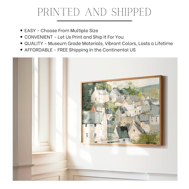 May include: A framed landscape painting of a village with white buildings and green trees. The artwork is in a wooden frame and hangs on a white wall. The text "PRINTED AND SHIPPED" is at the top.
