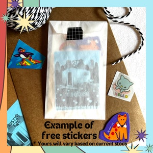 May include: A brown paper envelope with a white envelope inside. The white envelope has a variety of stickers on it, including a penguin on a surfboard, a cat with the word "HELLO" and a dog with red spots. The text "Example of free stickers" is written on the brown envelope. The text "*Yours will vary based on current stock" is also written on the brown envelope.
