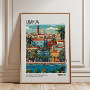 May include: A framed art print featuring a colorful illustration of Luanda, Angola. The artwork depicts a cityscape with buildings in shades of blue, red, and yellow, palm trees, and a body of water. The text "LUANDA" and "ANGOLA" are displayed at the top.