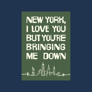 May include: A rectangular graphic on a navy blue background. The graphic is olive green and features the text "NEW YORK, I LOVE YOU BUT YOU'RE BRINGING ME DOWN" in white block letters. A white line drawing of the New York City skyline is at the bottom.