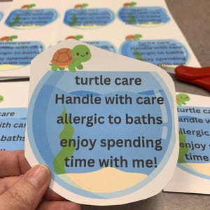 May include: A sticker featuring a cartoon turtle in a blue fishbowl design. The text says "turtle care, Handle with care, allergic to baths, enjoy spending time with me!" Other stickers are visible.