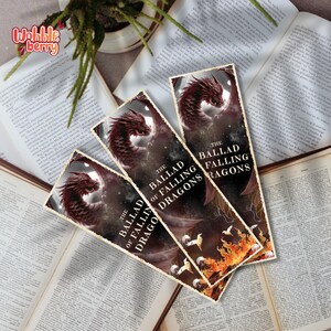 Pode incluir: Três marcadores retangulares com uma ilustração de dragão vermelho e o texto "The Ballad of Falling Dragons" são exibidos em livros abertos. O fundo é escuro com um design flamejante.