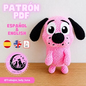 May include: A pink crocheted dog plush with long black ears, a large black nose, and wide white eyes with black pupils. Text reads PATRÓN PDF, ESPAÑOL & ENGLISH, and @Trabajos_lady_luna, accompanied by Spanish and American flag icons and a PDF symbol.