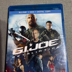 May include: A blue Blu-ray case for the movie "G.I. Joe: Retaliation" featuring Dwayne Johnson, Bruce Willis, and other actors. The case includes the text "Blu-ray + DVD + Digital Copy."