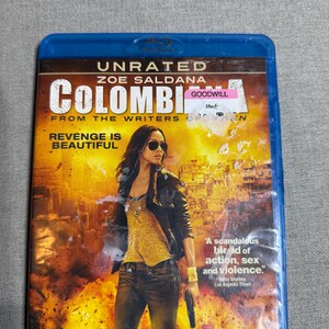 Może przedstawiać: Niebieskie pudełko Blu-ray filmu "Colombiana" z Zoe Saldaną. Okładka przedstawia kobietę trzymającą broń przed eksplozją. Widoczny jest również tekst "Revenge is Beautiful".