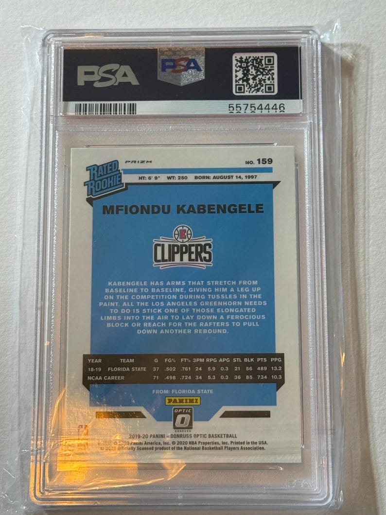 May include: A basketball trading card of Mfiondu Kabengele in a PSA holder. The card features the Clippers logo and player stats. The card is from the 2019-20 Panini Donruss Optic Basketball series. The card is in a clear plastic case.