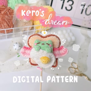 Puede incluir: Un patrón digital para tejer a crochet una linda rana verde durmiendo en un huevo frito dentro de una rebanada de pan. El patrón se llama "Kero's Dream".