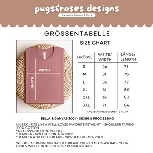 May include: A dusty rose-colored t-shirt displayed on a woven surface. The image includes a size chart with measurements in centimeters, and text that reads "pugstroses designs" and "Awesome Apparel & More."