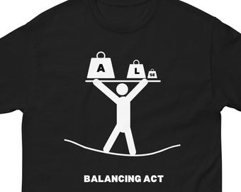May include: A black t-shirt with a white graphic of a stick figure balancing three weights labeled 'A', 'L', and 'SE' on a tightrope. The text 'BALANCING ACT' is below the graphic.