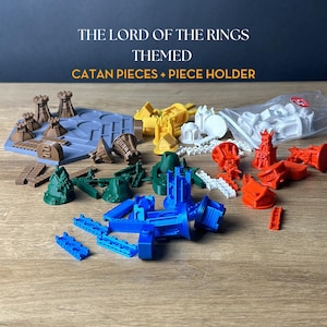 Puede incluir: Piezas de juego Catan con temática de El Señor de los Anillos y un soporte para piezas. Las piezas son de varios colores, incluyendo marrón, amarillo, verde, azul, rojo y blanco. El soporte para piezas es una bandeja de plástico gris con ranuras para cada tipo de pieza.