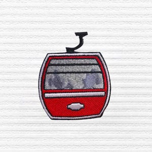 May include: Embroidered patch featuring a red and gray ski lift cabin with a black top and white border. The patch is designed with a detailed, stitched appearance, perfect for adding to clothing or accessories.