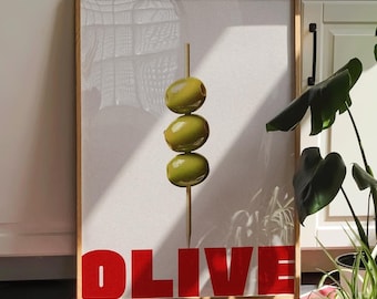 May include: A framed print with a white background and a green olive on a stick. The print has the word "OLIVE" in red letters at the bottom.