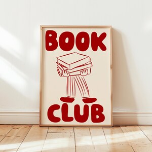 May include: A red and white poster with the text "BOOK CLUB" in large, bold letters. A stick figure illustration of a person carrying a stack of books is below the text.