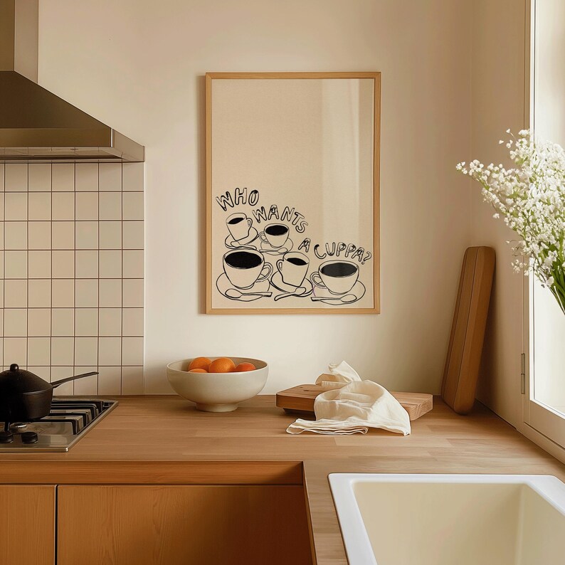 May include: A framed print with a black and white illustration of coffee cups and the text "Who wants a cuppa?"