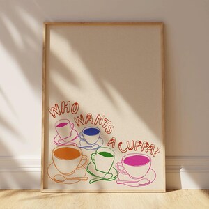 May include: A framed print with the text "Who wants a cuppa?" in red and orange. Five colorful teacups are arranged in a semi-circle below the text.