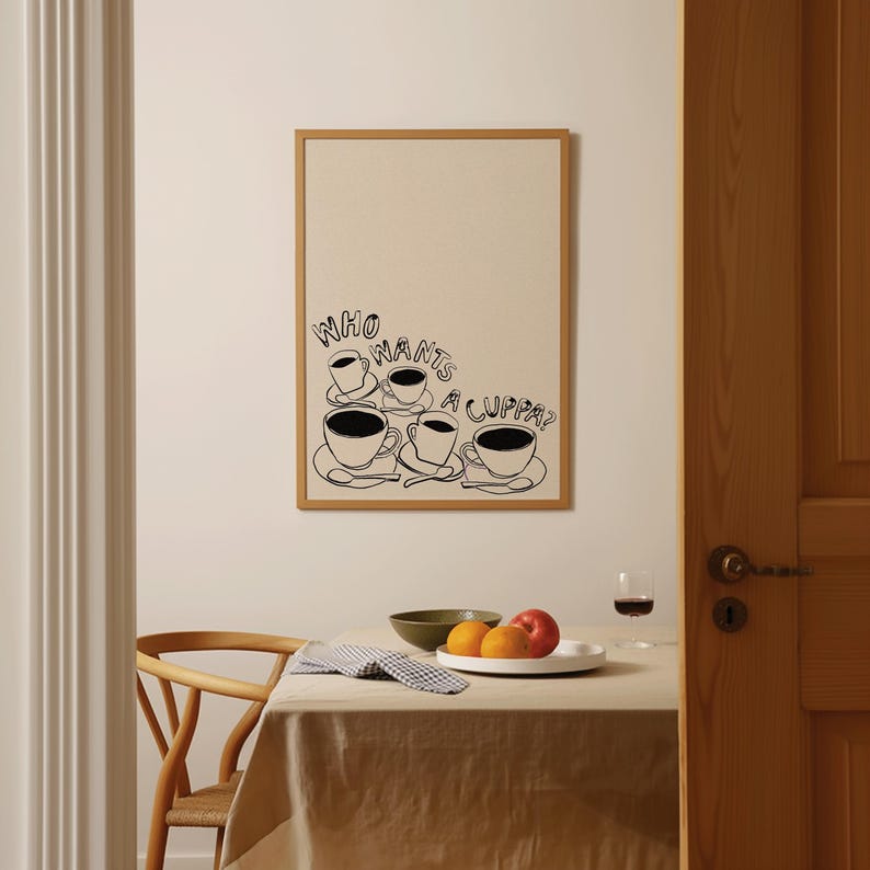 May include: A black and white illustration of five coffee cups with the text "Who wants a cuppa?" printed on a beige background. The illustration is framed in a light brown frame.