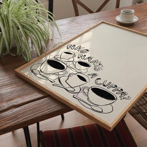 May include: A framed print with a white background and black text that reads "Who wants a cuppa?" with a drawing of five teacups and saucers.
