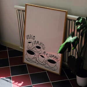 May include: A framed print with a black and white illustration of five teacups and the text "Who wants a cuppa?"