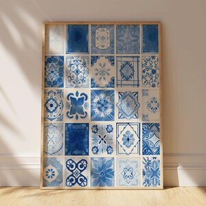 Könnte beinhalten: Ein gerahmter Druck mit einer Anordnung von blau-weiß gemusterten Fliesen. Die Fliesen zeigen verschiedene florale und geometrische Muster und bilden ein dekoratives Kunstwerk. Der Rahmen besteht aus hellem Holz.
