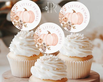 May include: Three cupcakes with white frosting and decorative sprinkles, topped with round toppers. The toppers feature a watercolor pumpkin design with the text "LITTLE PUMPKIN" and floral accents. The cupcakes sit on a wooden serving board.