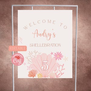 Könnte beinhalten: Ein rechteckiges Schild mit dem Text "WELCOME TO Audry's SHELLEBRATION" und der Zahl "5", die über einer großen rosa Muschelillustration zentriert ist. Das Design enthält Korallen-, Seestern- und Blumengrafiken in Rosa- und Pfirsichtönen.