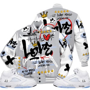 May include: A gray and white varsity jacket with graffiti-style text and graphics, including the word "Love", crowns, and smiley faces. The jacket is paired with white sneakers with blue soles. Text on the jacket reads "Let Every Moment Inspire You" and "All You Need Is Love".