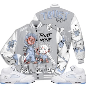 May include: A gray and white varsity jacket with the text "TRUST NO ONE" and illustrations of horror movie characters. The jacket is paired with white and light blue sneakers.