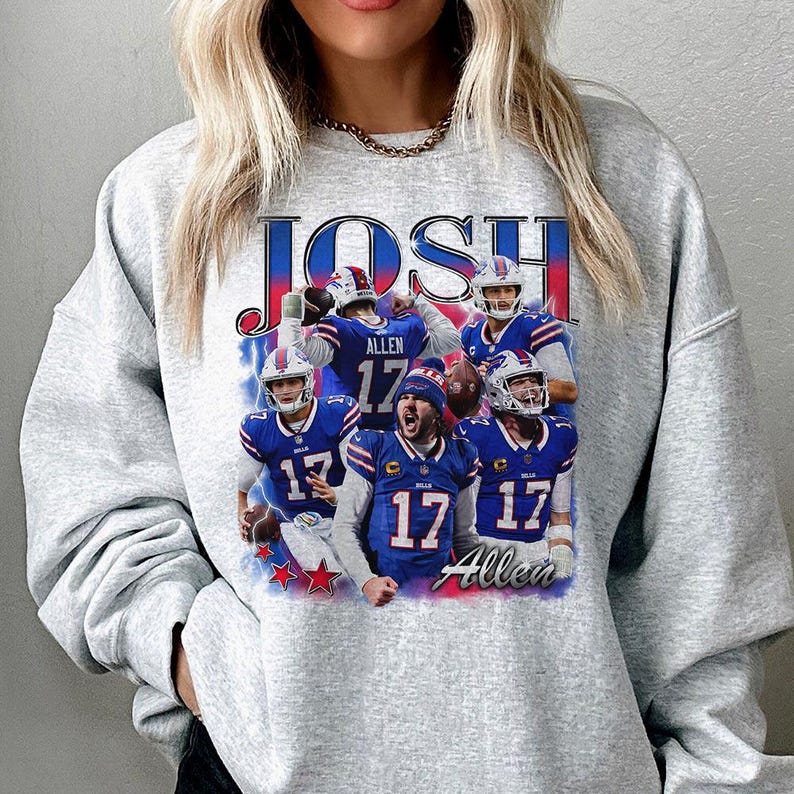 May include: A light gray crewneck sweatshirt featuring a graphic print of football player Josh Allen in a blue Buffalo Bills uniform. The design includes the text JOSH at the top and Allen at the bottom, with multiple action shots of the player.