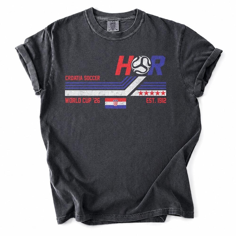 May include: Dark gray t-shirt with a graphic design featuring the text "HR", a soccer ball, and the Croatian flag. The design includes the words "Croatia Soccer", "World Cup '26", and "Est. 1912".