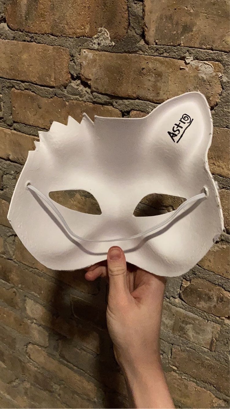 May include: White cat mask with elastic straps and the word 'ASTRO' written on the side.