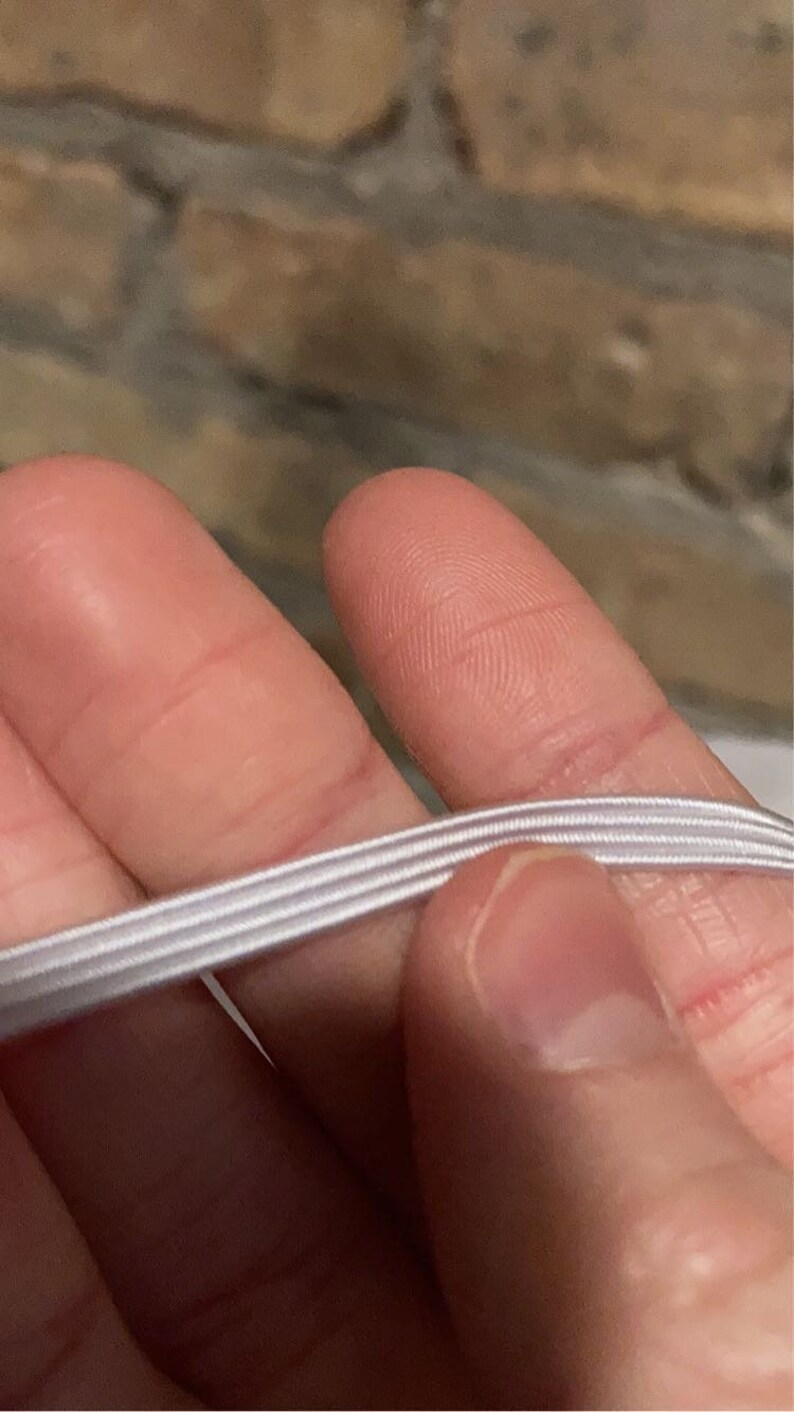 May include: White elastic string with three rows of stitching.