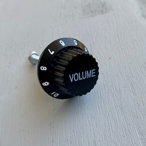 May include: Black volume knob with white numbers 1 through 10 and the word "VOLUME" printed on the front.