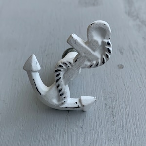 May include: White metal anchor hook with a rope design. The hook is distressed and has a rustic look.
