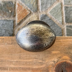 May include: A silver oval-shaped cabinet knob with a brushed finish.
