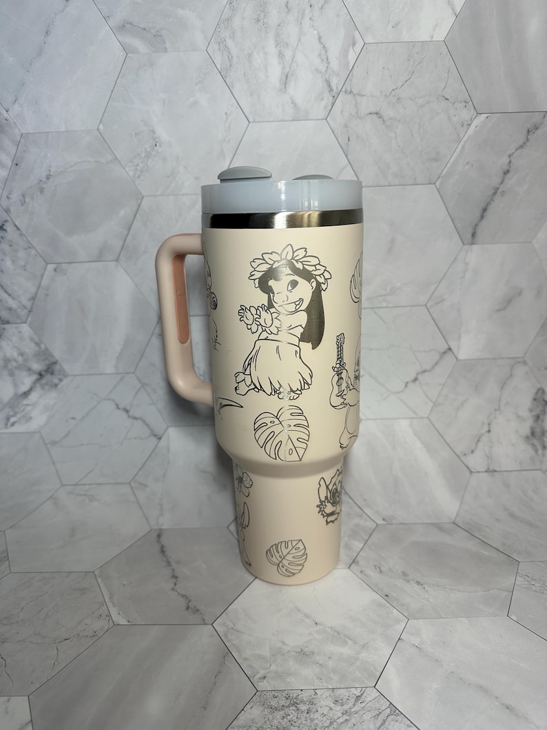 May include: A cream-colored stainless steel tumbler with a black and white design featuring Stitch and other characters from Lilo & Stitch. The tumbler has a handle and a lid with two buttons.